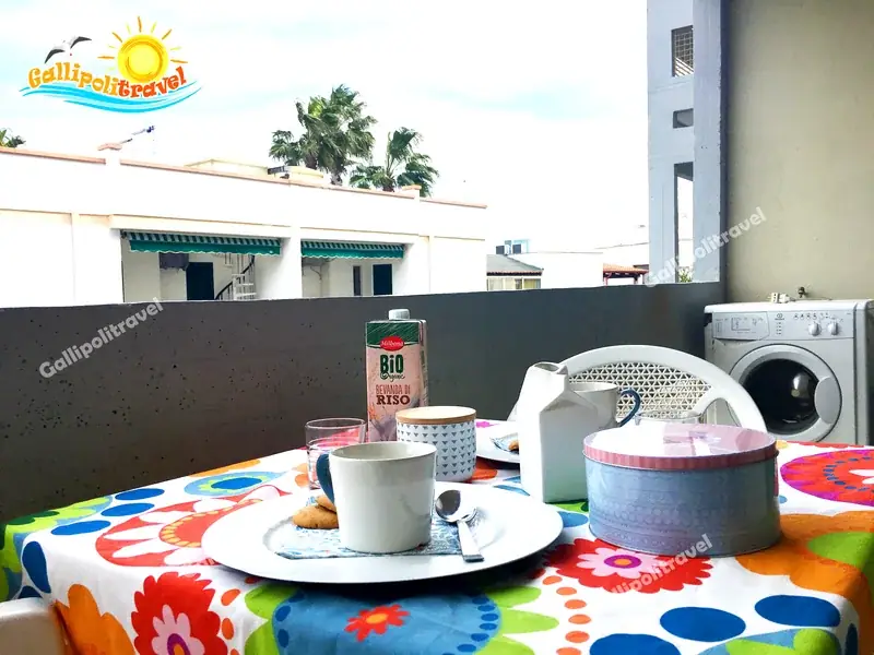 Balcone del Bilocale La Vela con colazione e tovaglia fiorata a Baia Verde