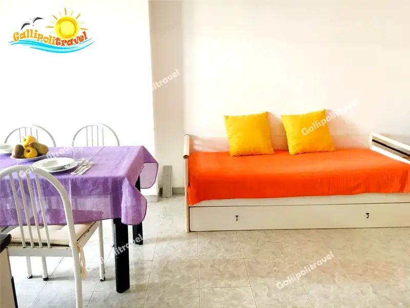 Soggiorno del Bilocale La Vela con divano-letto arancione e cuscini gialli