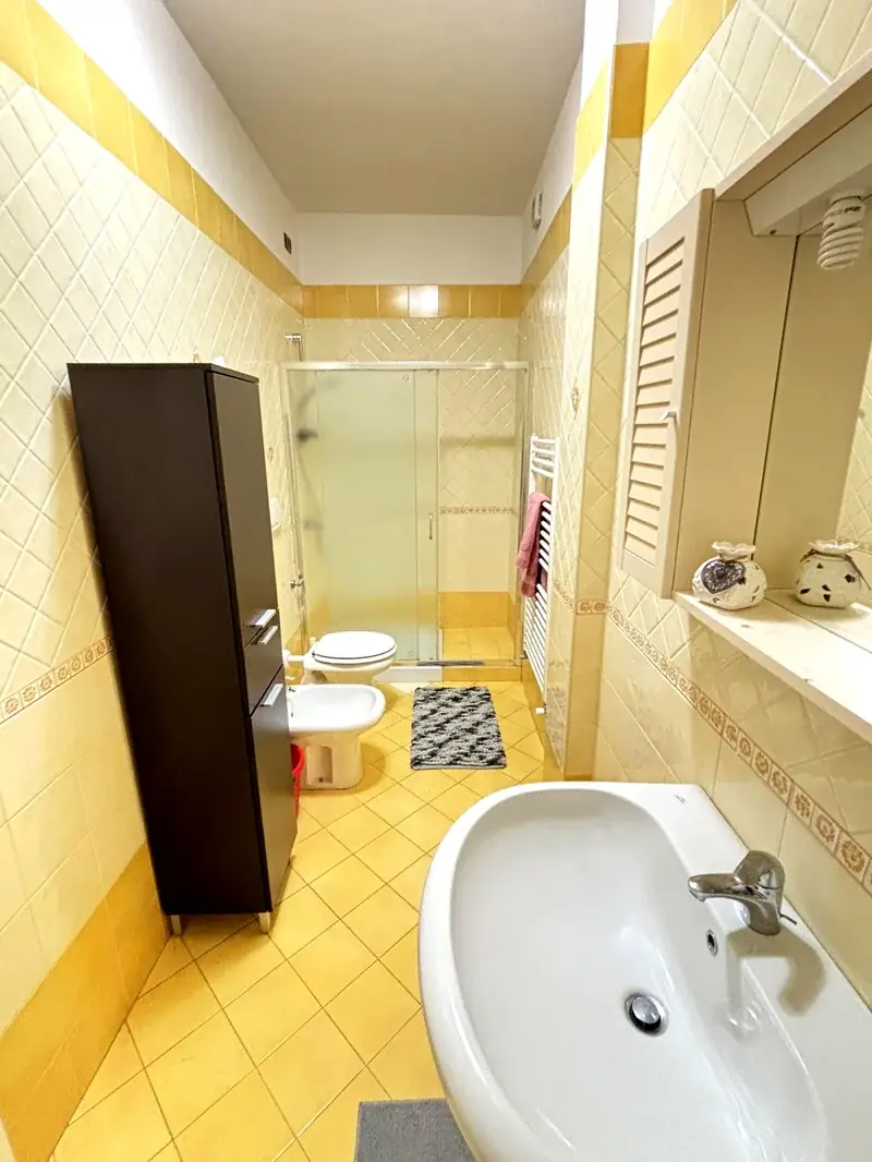 Bagno con piastrelle gialle e doccia del Trilocale B2/4 Gallipoli