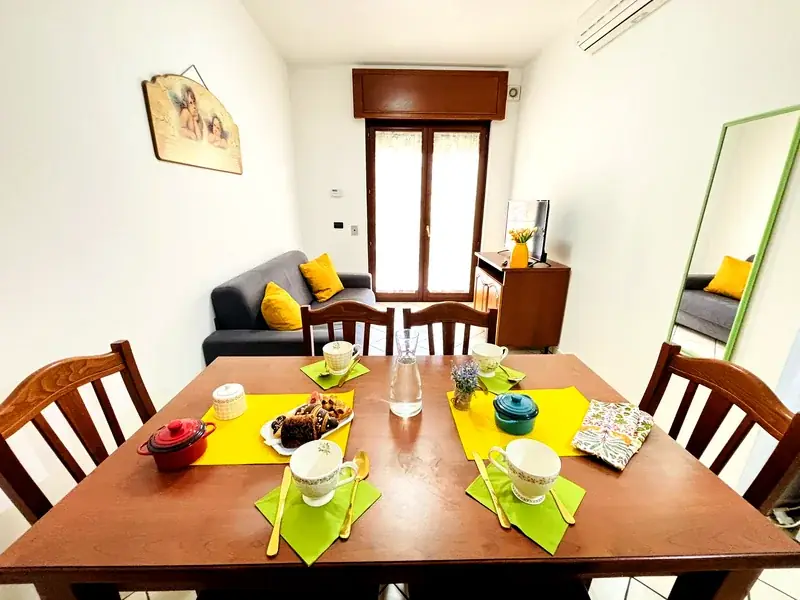 Soggiorno con tavolo pranzo e divano grigio del Trilocale B2/4 Gallipoli