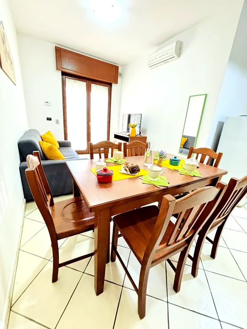 Zona pranzo con divano e cuscini gialli del Trilocale B2/4 Rosa Virginia Gallipoli