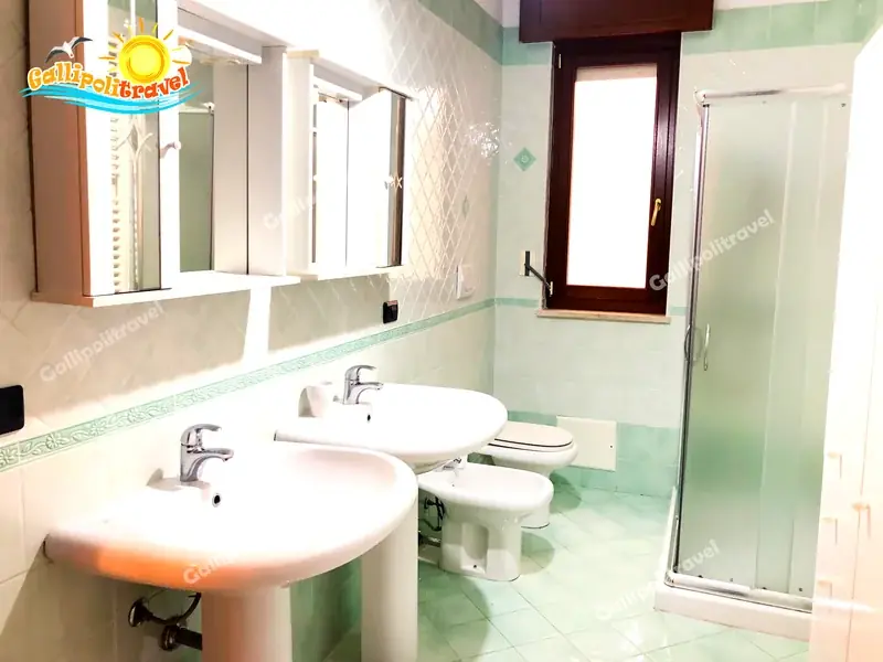 Bagno con piastrelle verde menta e doppio lavabo del Trilocale D1/3 Gallipoli