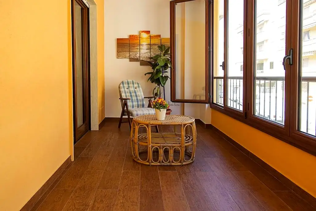 Veranda del Trilocale F1/1 con tavolino rattan e luce naturale