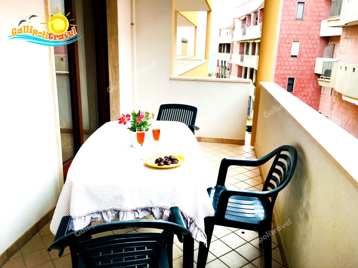 Balcone del Trilocale H2/2 al Residence Rosa Virginia con aperitivo, fiori e vista mare