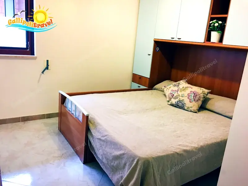 Camera del Trilocale H2/2 con letto a ribalta e armadio pensili in legno