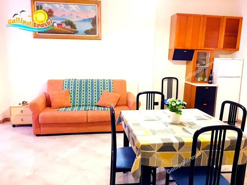 Zona giorno del Trilocale H2/2 con libreria, TV e porta-finestra luminosa