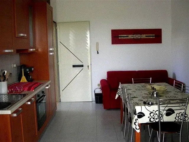 Cucina in legno con tavolo da pranzo e zona giorno del Trilocale Girasole