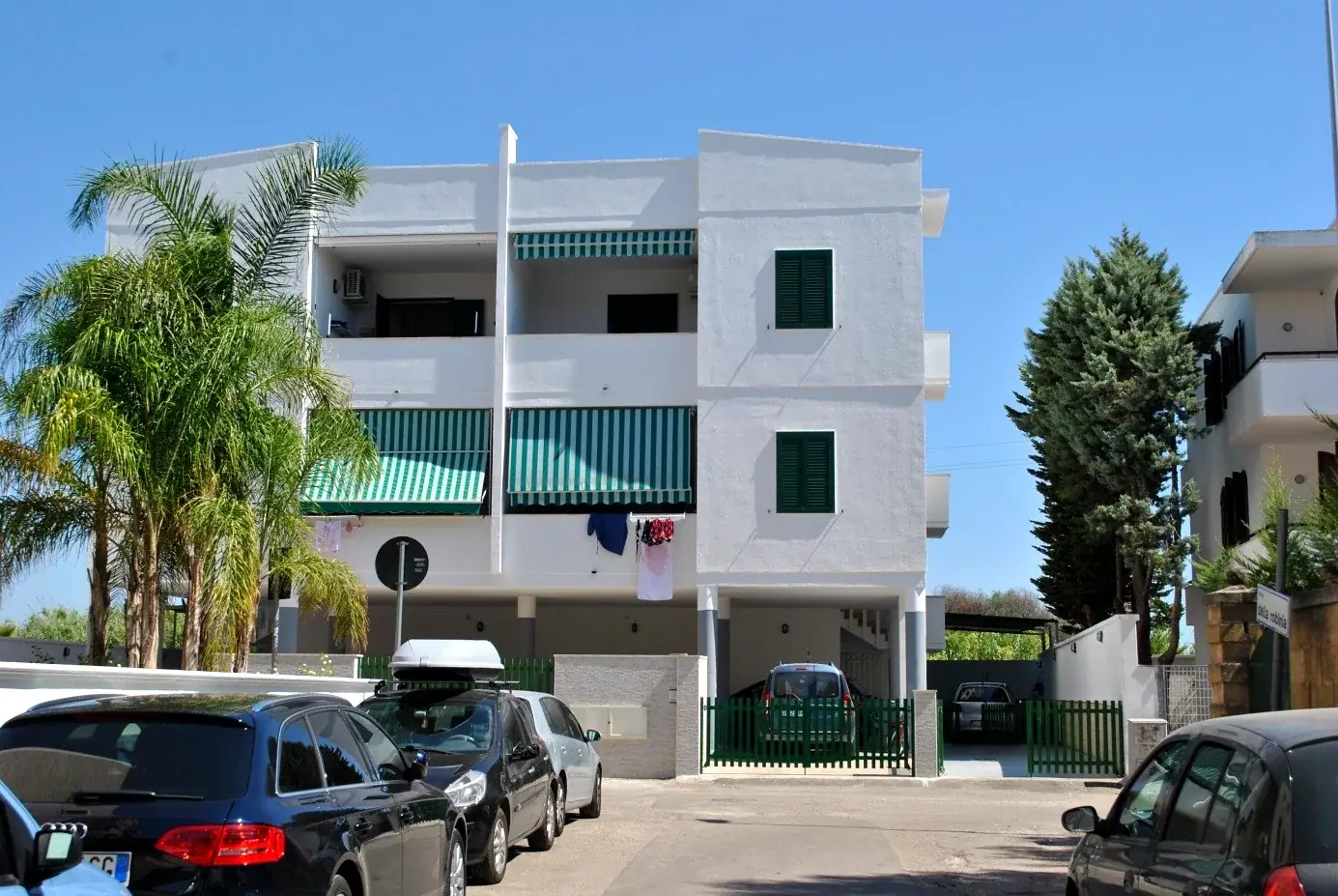 Facciata del Trilocale Girasole a Baia Verde Gallipoli con palme e cielo blu